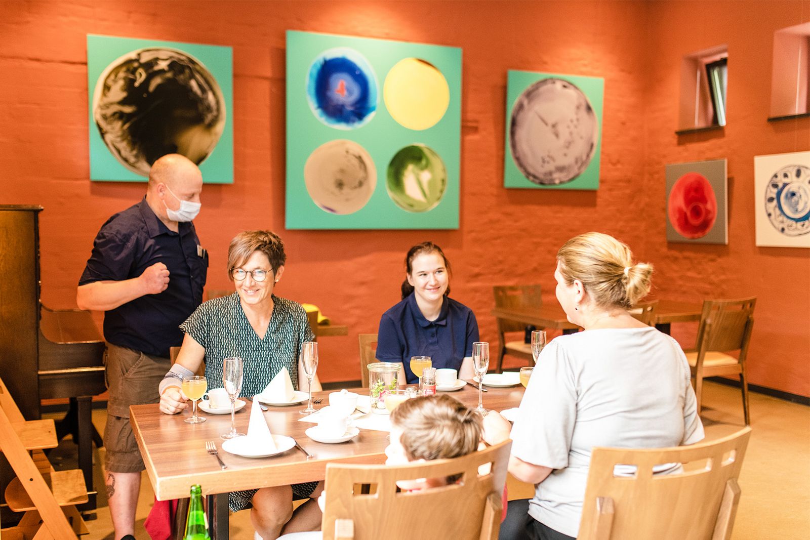 Gäste im Cafe, Galerie mit modernen Bildern im Hintergrund