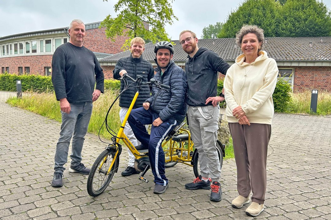Team und Bewohner der Wohngruppe Leo stehen am e-Dreirad 