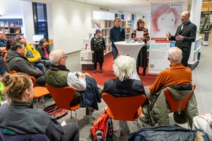 Das Publikum hört drei Künstlerinnen und Künstlern zu